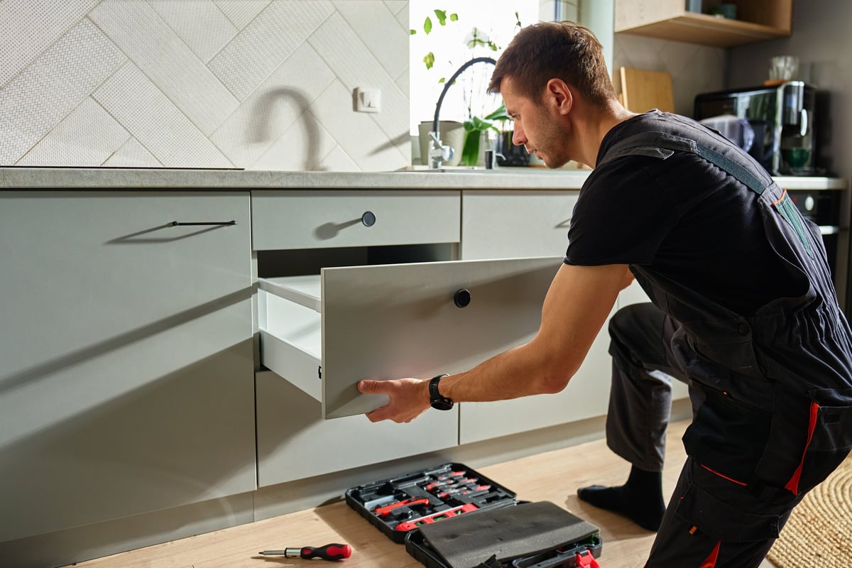 Person assembling kitchen drawer during renovation with cabinet hardware — CN Electrical kitchen rough-in and appliance circuit installation in Chilliwack, BC
