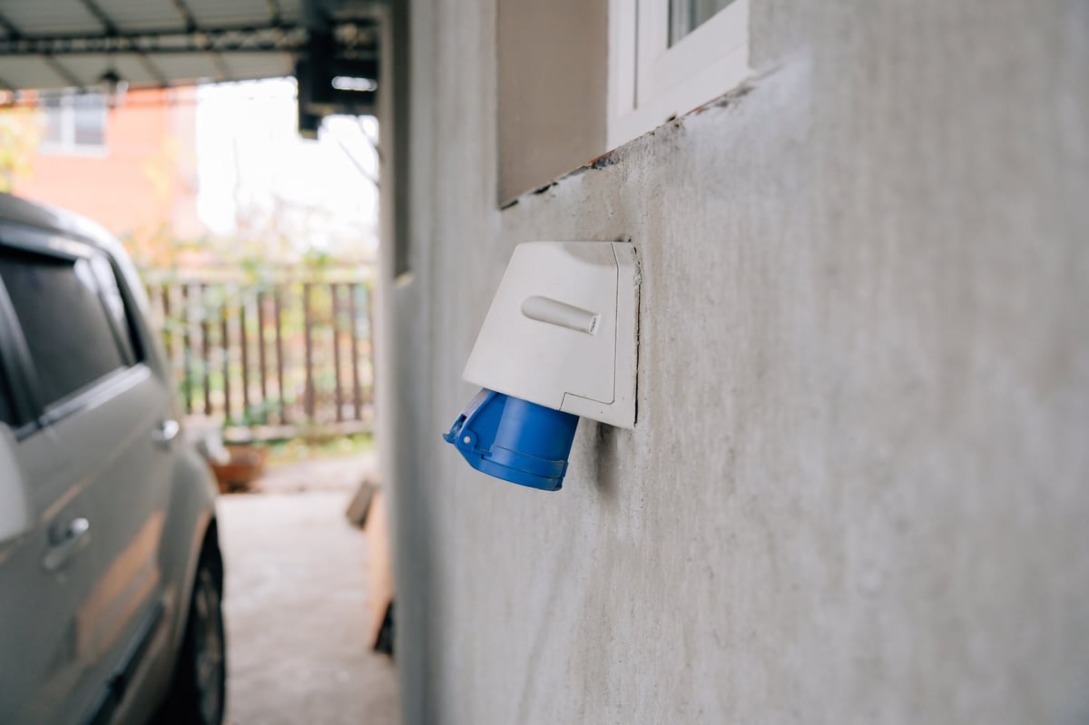 Electric vehicle owner plugs industrial-style power socket into home wall for convenient, energy-efficient residential charging — CN Electrical EV charger installation in Chilliwack, BC